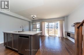 Clarington (Bowmanville) townhouse for rent - A modern kitchen with a sink, cabinets, and a window.