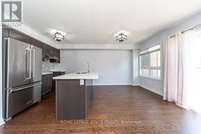 Clarington (Bowmanville) townhouse for rent - A kitchen with a refrigerator, sink, and cabinets.