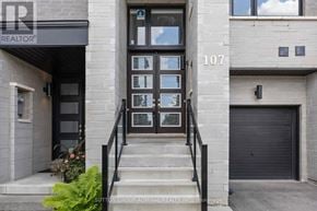 Vaughan (Patterson) townhouse for rent - The image shows the front of a building with the number 107 and a glass door.