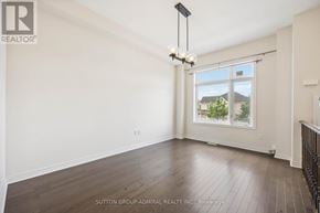 Vaughan (Patterson) townhouse for rent - A room with a window showing a view of a house and trees outside.