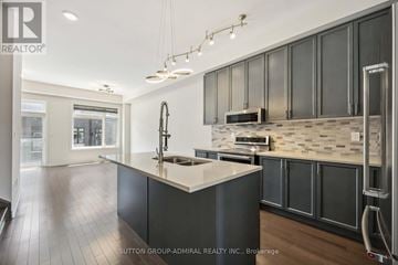 Vaughan (Patterson) townhouse for rent - A modern kitchen with dark wood cabinets and a white island.