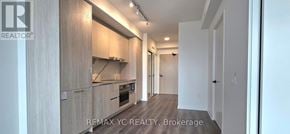 Vaughan (Vaughan Corporate Centre) condo for rent - A modern kitchen with wooden cabinets and a stainless steel range hood.