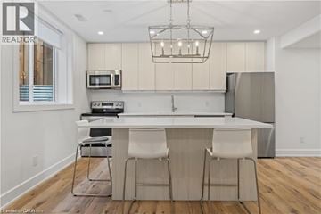 Ayr apartment for rent - A modern kitchen with a bar stool and a microwave above the counter.