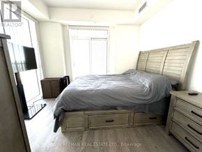 Mississauga (Central Erin Mills) condo for rent - A bedroom with a bed, nightstand, and a television.