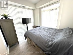 Mississauga (Central Erin Mills) condo for rent - A bedroom with a bed, nightstand, and a plant on a dresser.
