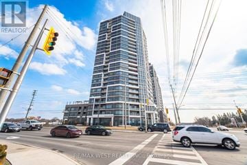 Milton (Co Coates) condo for rent - A tall building with many windows is in the background of a busy street.
