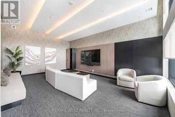 Milton (Co Coates) condo for rent - A modern living room with a large television and comfortable seating.