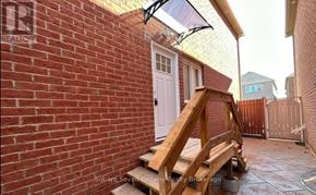 Brampton (Bram East) apartment for rent - A small patio with a white door and a wooden bench.