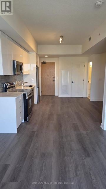 Brantford condo for rent - A kitchen with white cabinets and a wooden floor.