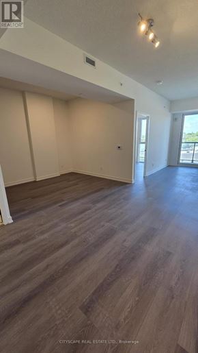 Brantford condo for rent - A room with a view of a parking lot through a glass door.