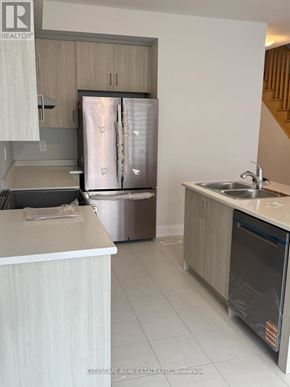 Kawartha Lakes (Lindsay) townhouse for rent - A kitchen with a refrigerator, sink, and cabinets.