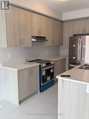 Kawartha Lakes (Lindsay) townhouse for rent - A kitchen with a refrigerator, sink, and cabinets.