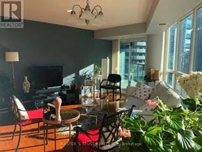 Toronto (Waterfront Communities) condo for rent - A living room with a television, chairs, and a table.