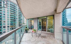 Toronto (Waterfront Communities) condo for rent - A balcony with a table and chairs overlooks a cityscape.