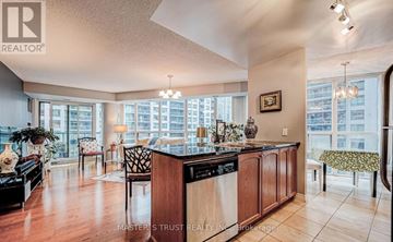 Toronto (Waterfront Communities) condo for rent - A kitchen with a wooden island and a dining table with chairs.