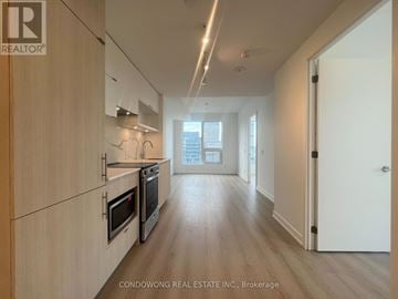 Toronto (Church-Yonge Corridor) condo for rent - A modern kitchen with wooden cabinets and stainless steel appliances.