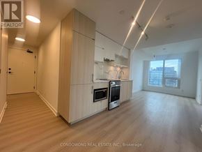 Toronto (Church-Yonge Corridor) condo for rent - A spacious kitchen with wooden cabinets and stainless steel appliances.