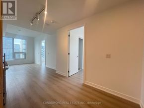 Toronto (Church-Yonge Corridor) condo for rent - A spacious room with wood flooring and white walls, with a doorway leading to another room.