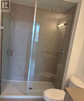 Oakville (Jm Joshua Meadows) condo for rent - A bathroom with a glass shower stall and a toilet.