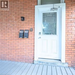 Hamilton apartment for rent - A white door with a glass window is set in a red brick wall.