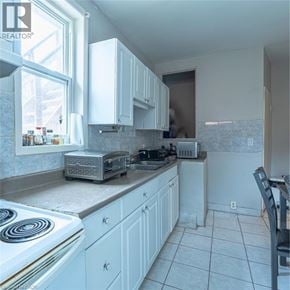 Hamilton apartment for rent - A kitchen with white cabinets and a stove top oven.
