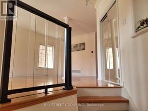 Markham (Berczy) apartment for rent - A glass door with a black frame is in the foreground of a white room.