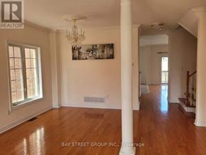 Markham (Berczy) apartment for rent - A spacious room with wooden floors and white walls, with a chandelier hanging from the ceiling.
