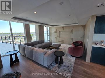 Burlington (Alton) condo for rent - A living room with a grey couch and a red chair.