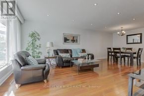 Mississauga (Erindale) apartment for rent - A living room with a grey couch, a coffee table, and a dining table with chairs.