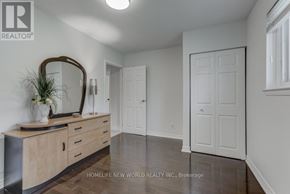 Mississauga (Erindale) apartment for rent - A realtor photo of a white hallway with a wooden dresser and a mirror.