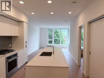 Squamish apartment for rent - A modern kitchen with white cabinets and a large island.