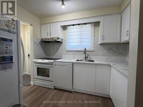 Welland (N. Welland) apartment for rent - A white kitchen with a sink and a refrigerator.