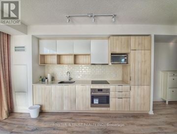 Toronto (Henry Farm) condo for rent - A kitchen with wooden cabinets and a white countertop.