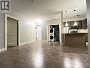 Burnaby apartment for rent - A spacious room with a kitchen area in the background.