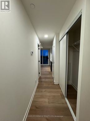 Brantford condo for rent - A long hallway with white walls and wood flooring.