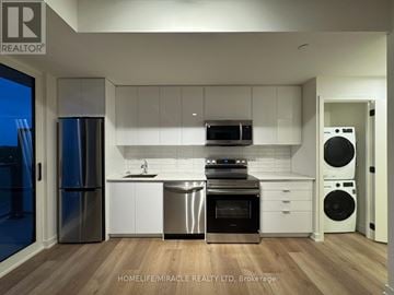 Brantford condo for rent - A modern kitchen with stainless steel appliances and white cabinets.