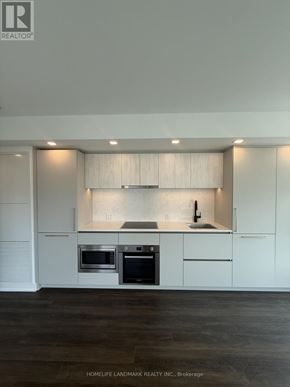 Toronto (North St. James Town) condo for rent - A modern kitchen with white cabinets and stainless steel appliances.