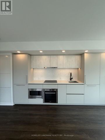 Toronto (North St. James Town) condo for rent - A modern kitchen with white cabinets and stainless steel appliances.