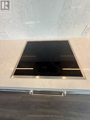 Toronto (North St. James Town) condo for rent - A modern kitchen with a marble backsplash and a stove top oven.
