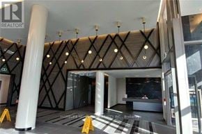 Toronto (Henry Farm) condo for rent - A modern building entrance with a white pillar and a black and white checkered floor.