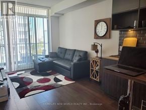 Toronto (Henry Farm) condo for rent - A living room with a black leather couch and a wooden coffee table.