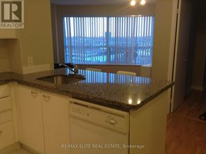 Toronto (Woburn) condo for rent - A kitchen with a granite countertop and white cabinets.