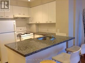 Toronto (Woburn) condo for rent - A kitchen with granite countertops and white cabinets.