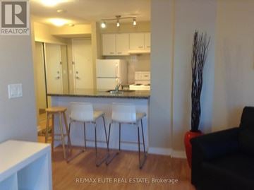 Toronto (Woburn) condo for rent - A kitchen with white chairs and a bar stool.