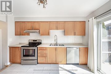 Milton (Be Beaty) townhouse for rent - A kitchen with wooden cabinets and a white backsplash.