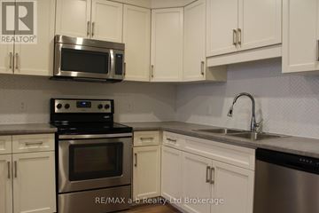 Woodstock (Woodstock - North) apartment for rent - A kitchen with white cabinets and a stainless steel oven and microwave.