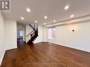Ajax (Northeast Ajax) apartment for rent - A spacious room with wooden floors and a staircase leading to another level.