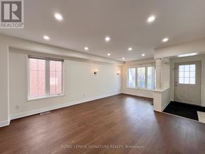 Ajax (Northeast Ajax) apartment for rent - A spacious room with wooden floors and white walls.