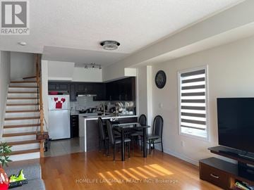 Toronto (L'amoreaux) townhouse for rent - A kitchen with a dining table and chairs in the middle of the room.