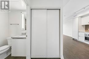 Mississauga (City Centre) condo for rent - A white bathroom with a toilet, sink, and a large white door.